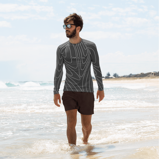 Man wearing a "Fun Wear Code" branded long-sleeve rash guard and swim shorts on a beach