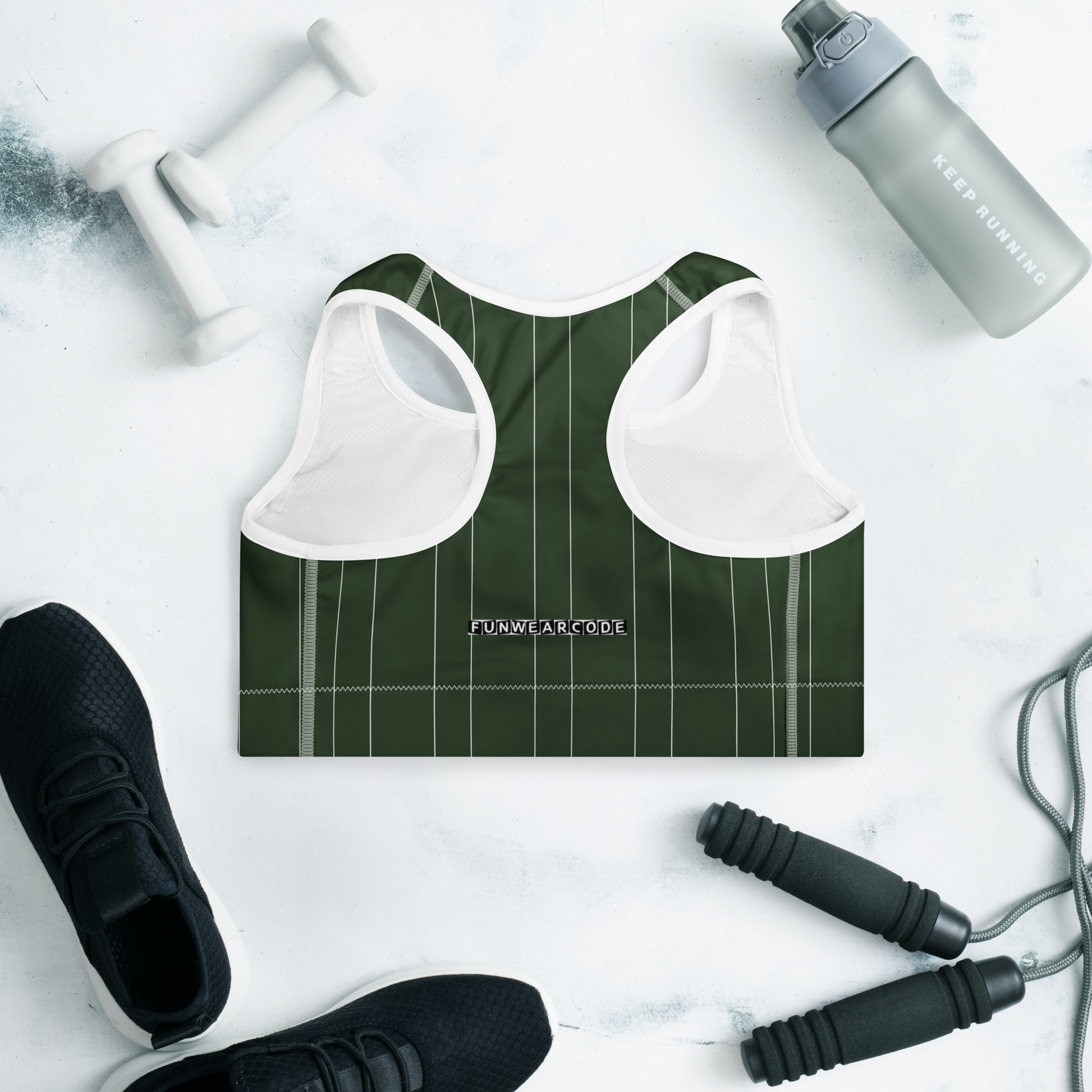 Green sports bra with a brand logo 'Funwearcode' on a light gray background with fitness equipment.