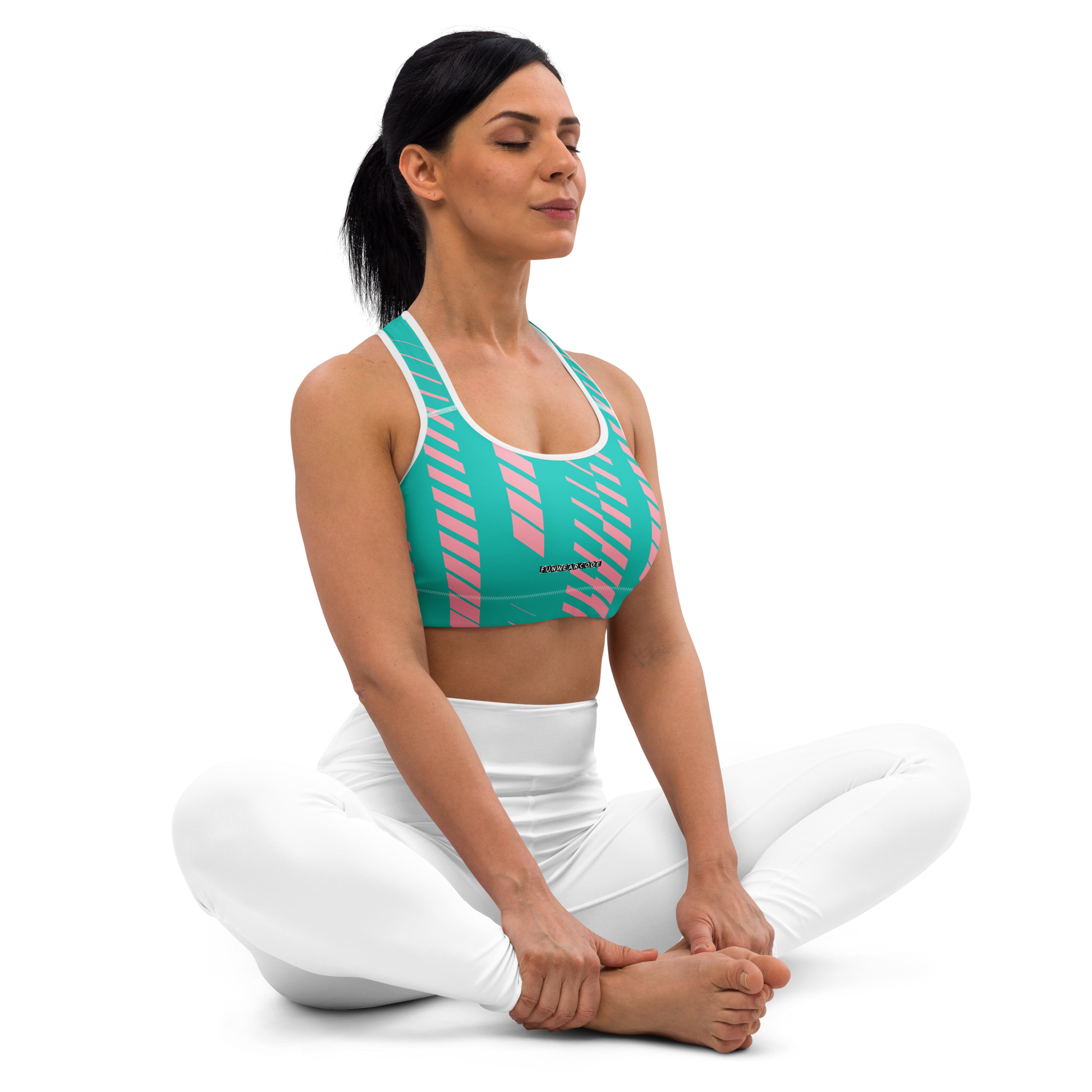 Woman wearing a green and pink sports bra and white pants on a white background