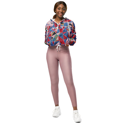 Person wearing a colorful geometric-patterned windbreaker and pink leggings on a white background