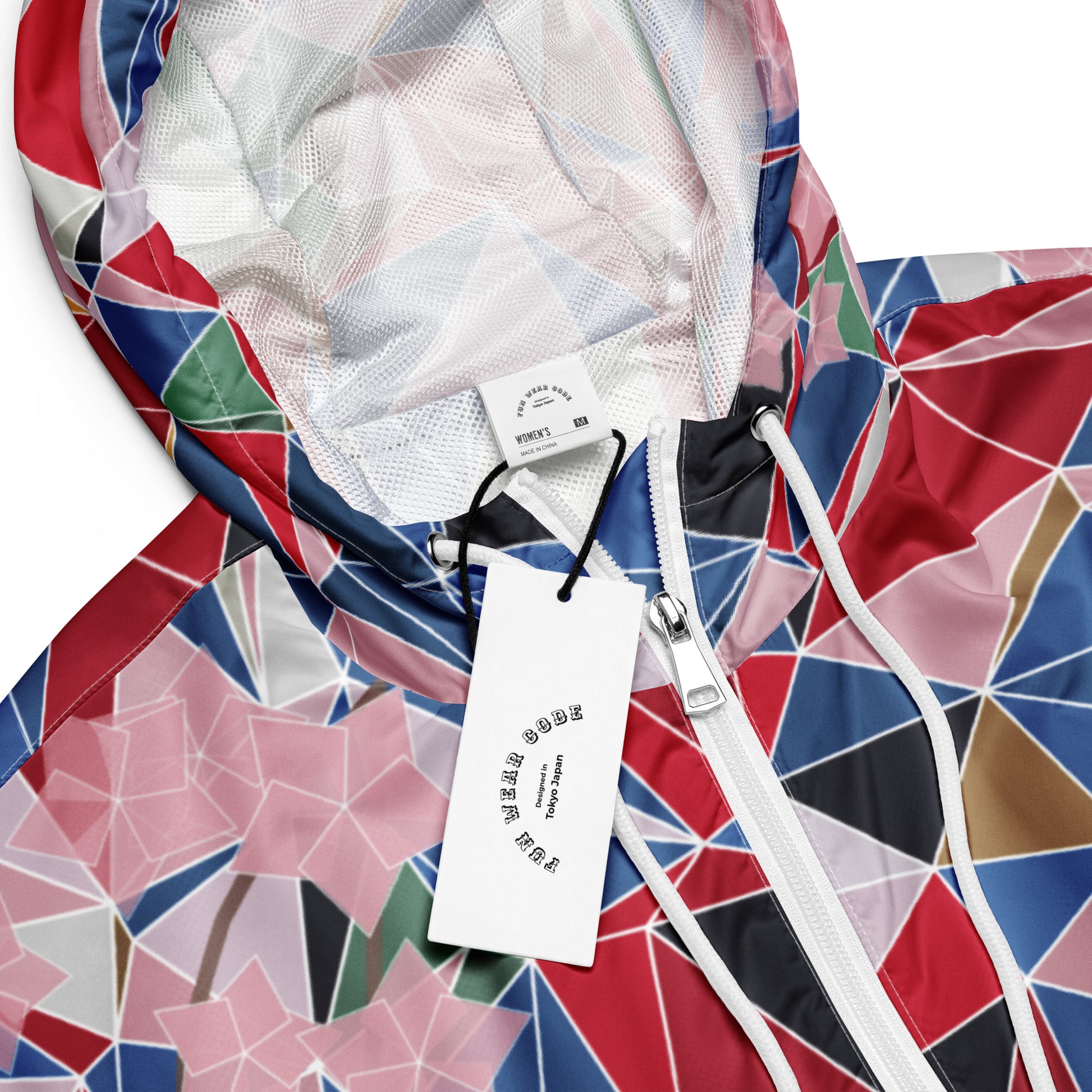 Colorful geometric-patterned jacket with a brand tag on a white background