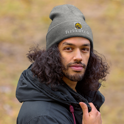 Man wearing a gray beanie with a FunWearCode logo and text, standing outdoors with a blurred natural background.